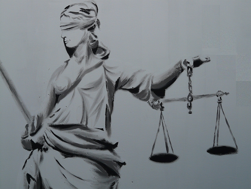 Bleistiftzeichnung der Iustitia. Sie träg ein langes, in Falten liegendes Kleid, in der linken Hand die Waagschale, rechts das Schwert und ein Tuch um ihre Augen gebunden.