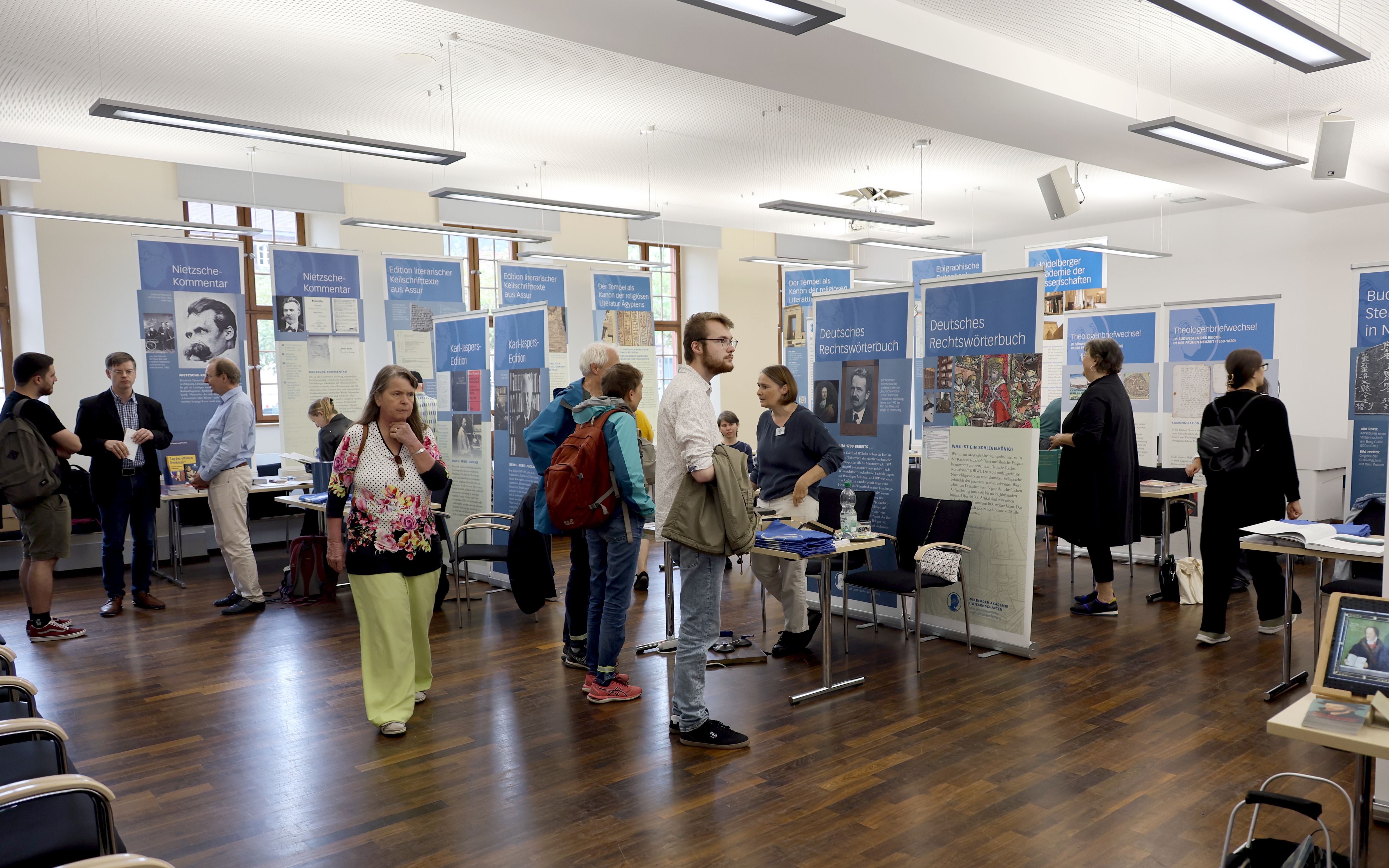 Besucherinnen und Besucher informieren sich an den Ständen der Forschungsstellen über die Akademiearbeit.