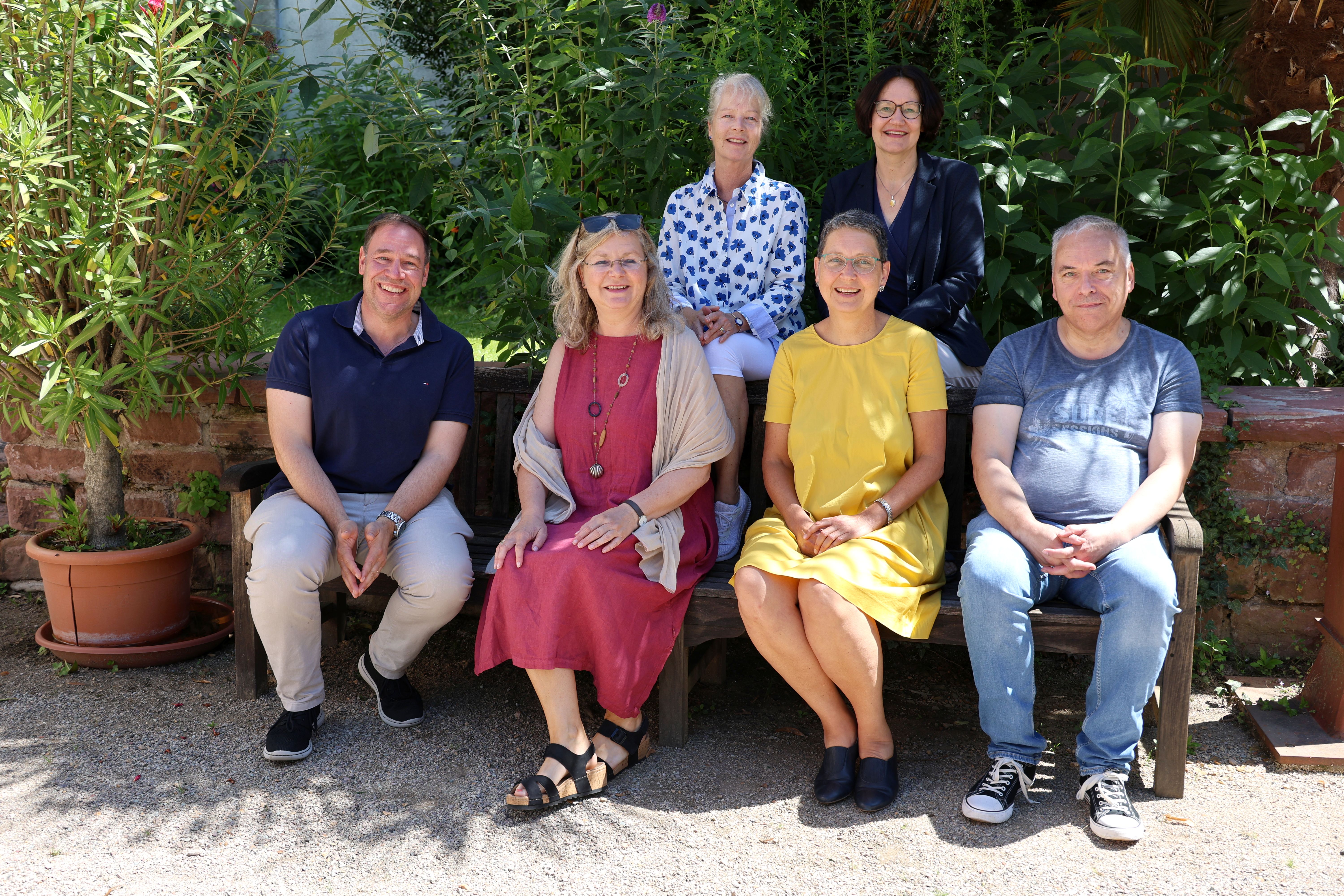 Gruppenbild im Freien: Auf einer Bank sitzen v.l.n.r. Herbert v. Bose, Birgit Eickhoff, Miriam Haidle und Volker Hartmann, dahinter sitzen Elke Schneider und Claudia Wenzel.
