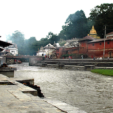 Das Foto zeigt einen Fluss neben einem Tempel. 