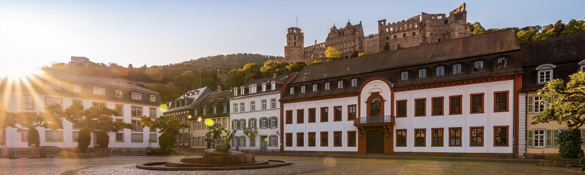 Akademiegebäude bei Sonnenaufgang mit dem Heidelberger Schloss im Hintergrund
