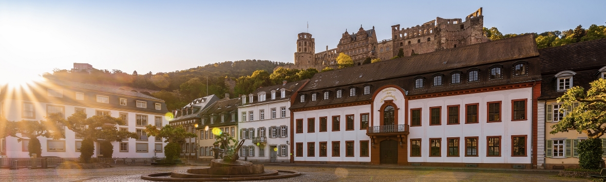 Akademiegebäude bei Sonnenaufgang mit dem Heidelberger Schloss im Hintergrund