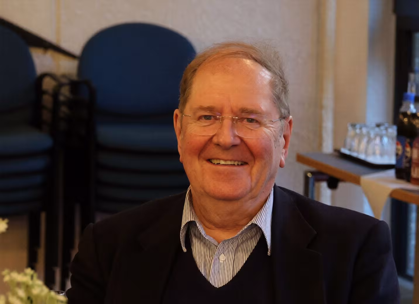 Michael Welker lächelt in die Kamera. Der Mann ist Ende 70 und  trägt eine Brille, hat eine hohe Stirn .