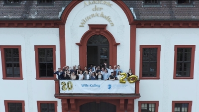 Kollegiaten winkend auf Balkon der Akademie