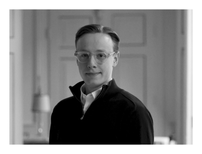 Dreiviertelporträt von Moritz Gaspard in Schwarzweis. Er trägt Brille und einen Seitenscheitel.