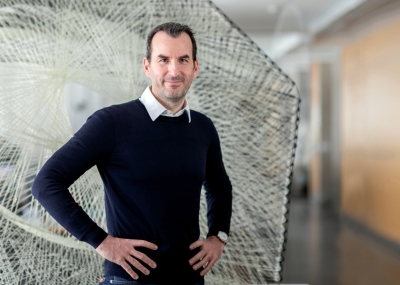 Foto von Achim Menges vor einem Kunstobjekt in einem schwarzen Pullover