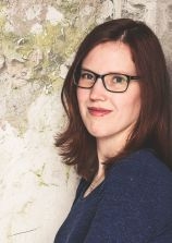 Portrait einer braunhaarigen Frau mit Brille.