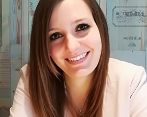 Portrait von Noémie Jaquier in halbnaher Aufnahme. Sie lächelt frontal in die Kamera. Sie trägt einen hellrosa Blazer, die langen Haare fallen offen über die Schultern.