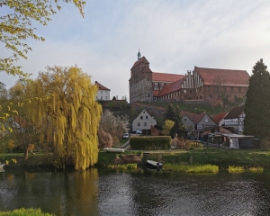 Fotografie, die eine Gesamtansicht des Doms zu Havelberg mit Landschaft zeigt