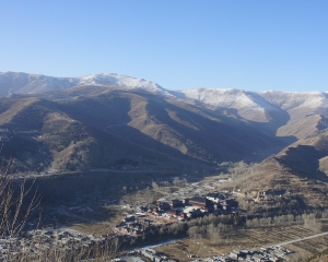 Blick von oben auf die Berge und die im Tal stehenden Tempel