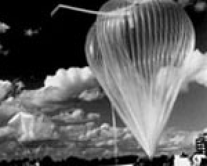 Schwarz-weiß Foto der Vorbereitungen zum Start des ballon-gestützten TDLAS-Spektrometer in Aire sur l’Adour; Ein transparenter Ballon ist vor einem wolkenbehangenen Himmel zu sehen. Der Himmel ist schwarz, der Ballon erscheint wie die Wolken weiß.