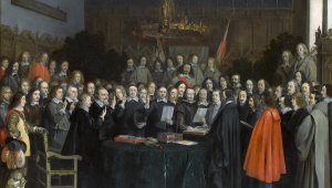 Malerei zum Westfälischen Frieden in Münster. Eine große Gruppe von Menschen steht hinter einem runden Tisch, der die Bildmitte bildet. Zwei von ihnen schauen jeweils auf ein Blatt Papier, alle anderen Personen haben den Blick auf die Männer gerichtet.