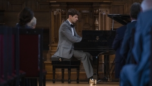 Fotografie des Pianisten Salyutov, während er bei der Jahresfeier auf einem Flügel spielt