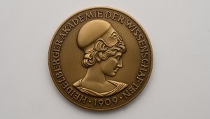Die Bronzemedaille zeigt den Kopf der Athene als griechischer Göttin der Wissenschaft. Am Rand der Medaille verläuft der Schriftzug Heidelberger Akademie der Wissenschaften 1909.   