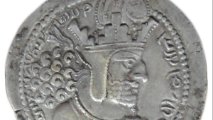 Silbermünze mit Prägung des Profils des Königs Schapur I., er ist mit einem dichten Bart, langem, gelockten Haar und strengem Blick dargestellt. Auf dem Kopf trägt er eine Krone
