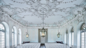 Das Bild des Mozartsaals im Schloss Schwetzingen zeigt den prächtigen Raum mit seinen Deckenornamenten und großen Bogenfenstern. 