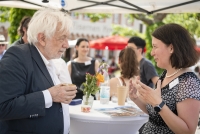 Ein Mann und eine Frau sind auf dem Karlsplatz in eine Unterhaltung über die Projekte des Wissenschaftlichen Nachwuchses der Heidelberger Akademie vertieft 